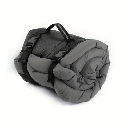 Gray sleeping bag rolled up with black straps on a white background