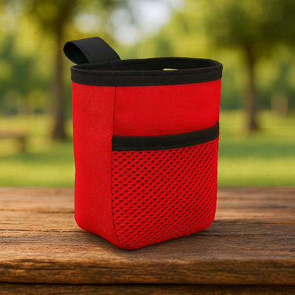 Red chalk bag with black accents on a wooden surface in a park setting